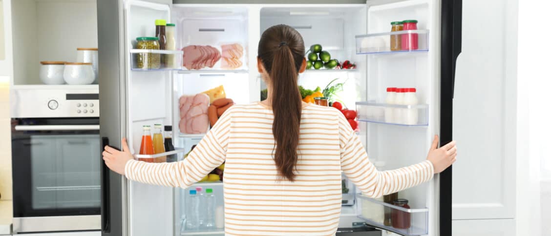 Femme devant un réfrigérateur ouvert