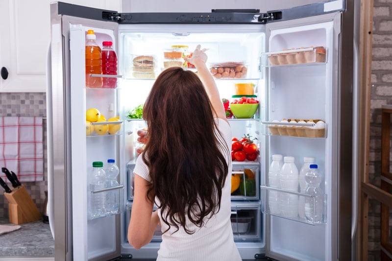 Femme qui ouvre son frigo